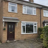 A semi-detached house with freshly cleaned windows.